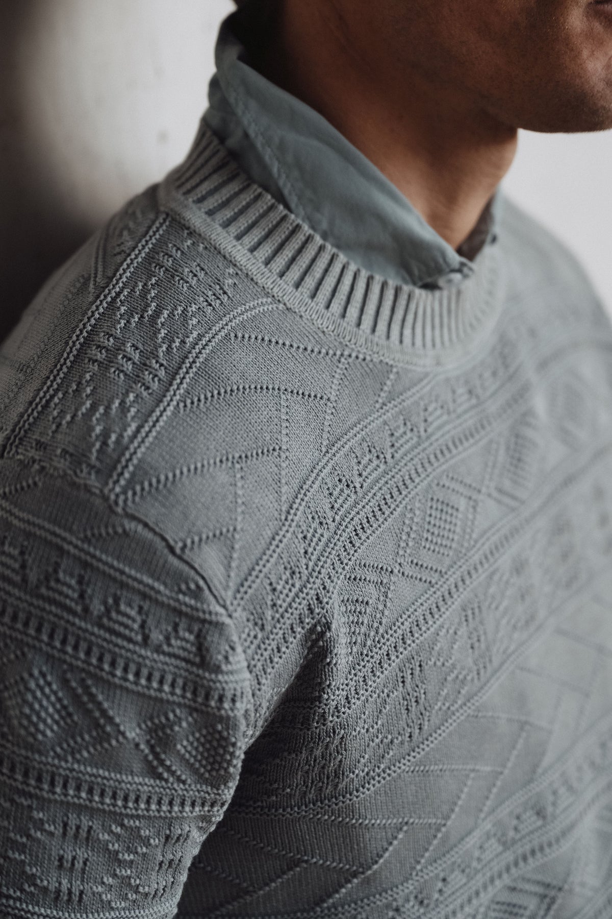 Men's knit sweater in light blue with textured diamond pattern and ribbed crew neck