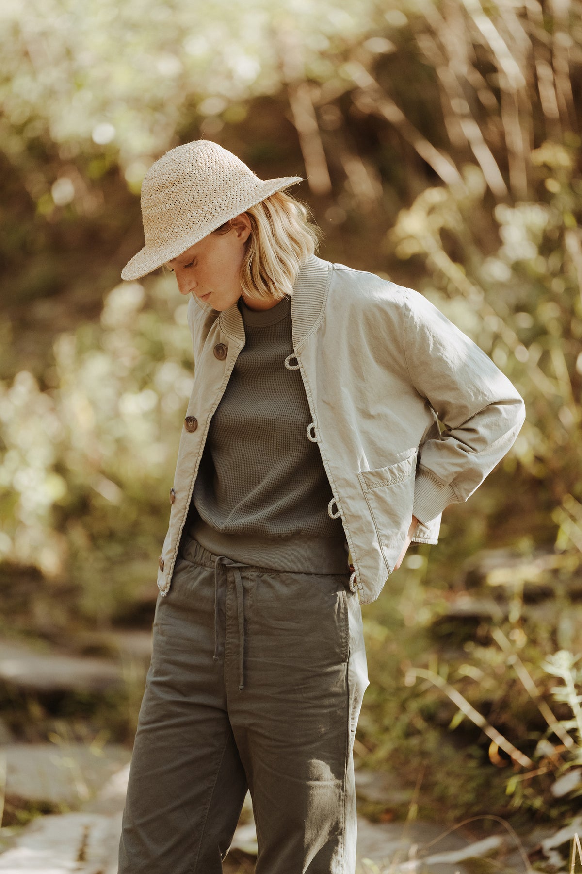 Olive surplus jacket with button front and two flap chest pockets, worn open.