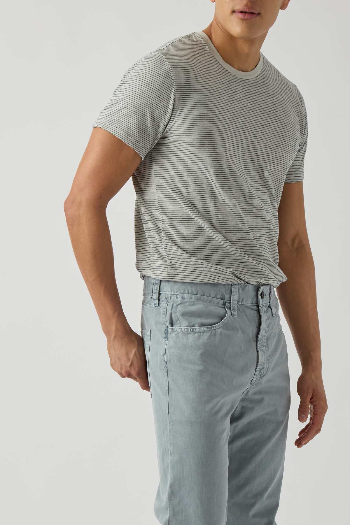 Model wearing light khaki standard jeans with front slant pockets and button fly